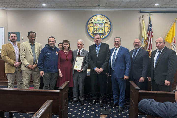 Members of the Parsippany town council surround Richard and Marie Onorevole as Richard holds a framed certificate.